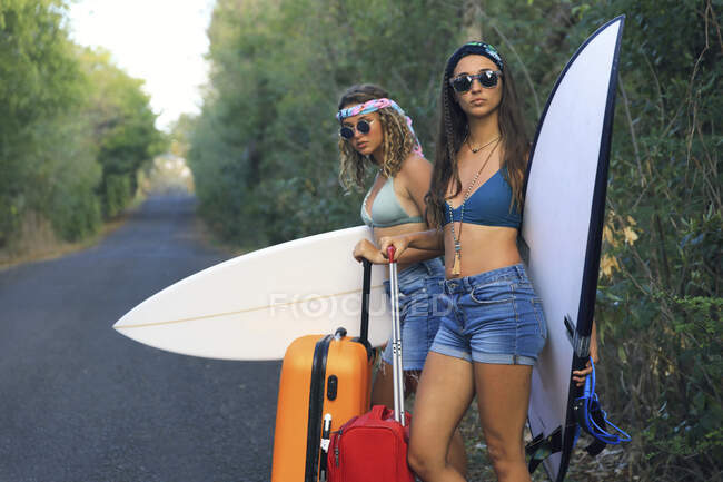 Uma rapariga com uma mala. Jovem e muito hippie em uma estrada deserta — Fotografia de Stock