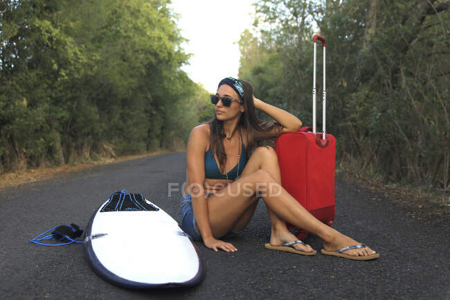 Дівчинка з валізою. Молодий і гарний гіпі на відлюдній дорозі — стокове фото