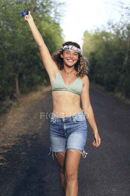 Jeune et jolie hippie sur une route déserte — Photo de stock