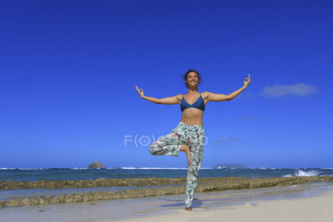 Jovem fazendo ioga na praia — Fotografia de Stock