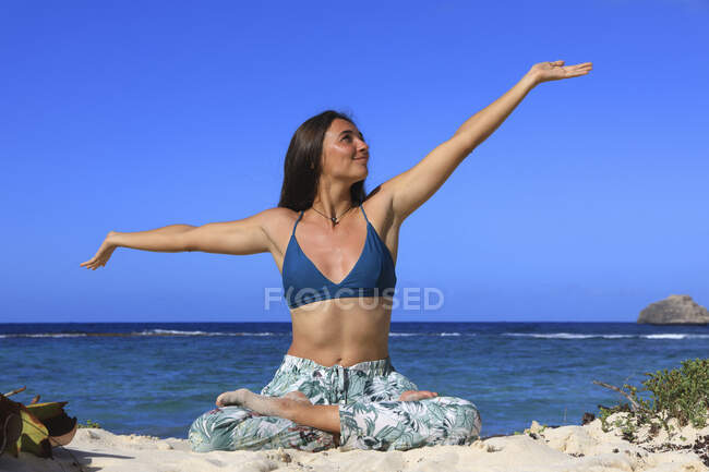 Giovane donna che fa yoga sulla spiaggia — Foto stock
