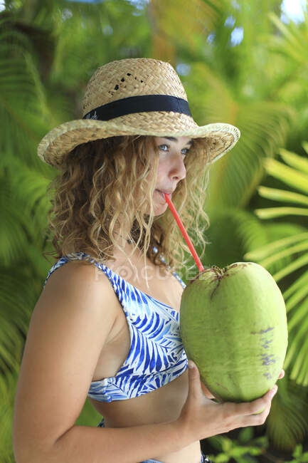 Retrato de uma menina exótica bebendo de um coco — Fotografia de Stock