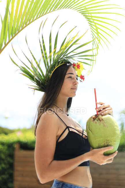 Retrato de uma menina exótica bebendo de um coco — Fotografia de Stock
