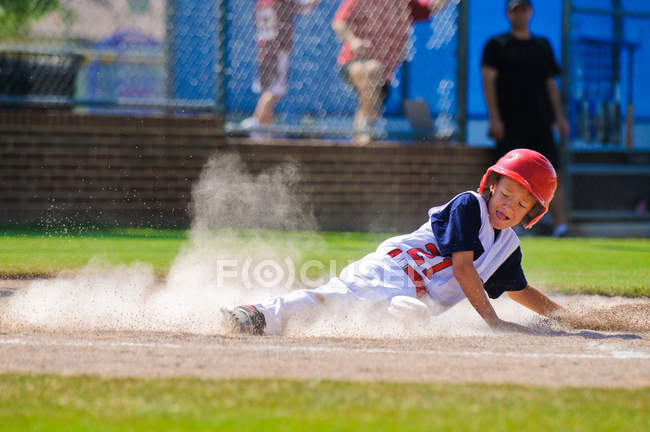 Joueur de baseball glissant dans la plaque de la maison — Photo de stock