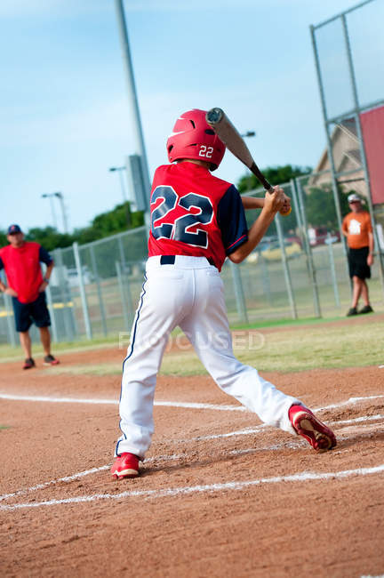 Молодой бейсболист размахивает битой — стоковое фото