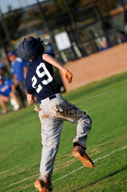 Joueur de baseball adolescent bases de course — Photo de stock