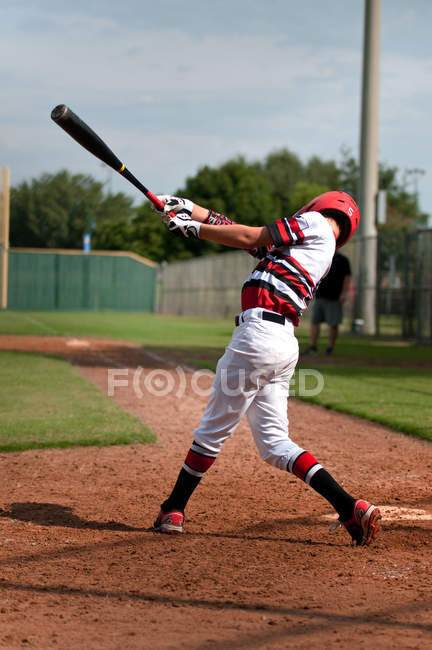 Jeune joueur de baseball balançant chauve-souris — Photo de stock