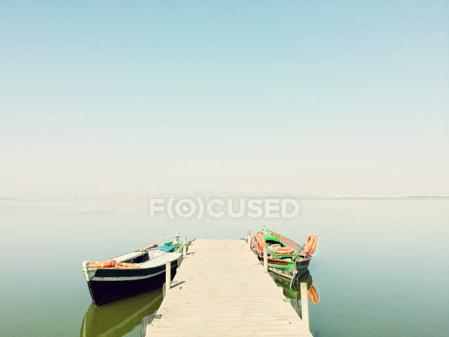 Спокойное озеро с двумя рыбацкими лодками — стоковое фото