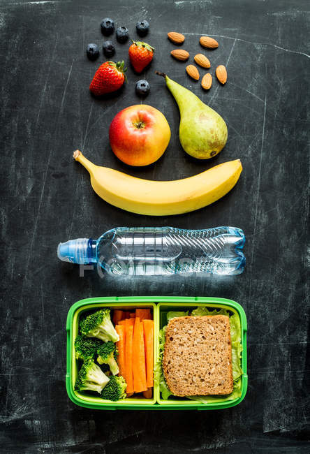 Pranzo scolastico con panino, verdura, acqua e frutta — Foto stock