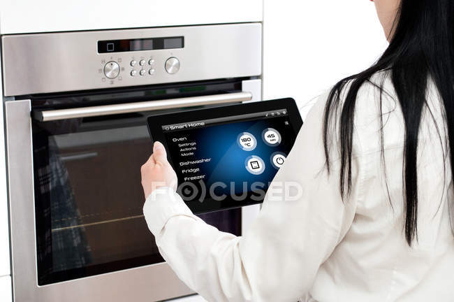 Una donna organizza un programma di cottura al forno. Concezione di utilizzare smart h — Foto stock
