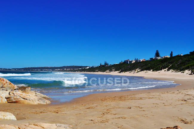 África do Sul: quebrando ondas e rochas vermelhas na praia de Plettenberg Bay, chamado Plet ou Plett, originalmente chamado Bahia Formosa (Baía Bonita), uma cidade ao longo da famosa Rota Jardim — Fotografia de Stock