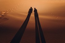 Silhouette di coppia sulla sabbia nel deserto di merzouga, marocco — Foto stock