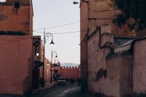 Marrakech, Marocco, Africa - 07 dicembre 2018: auto e moto in strada stretta con architettura tradizionale la sera, Marocco, Africa — Foto stock