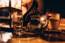 Nahaufnahme von glänzenden Teekannen und Gläsern mit Wasser und Getränk auf dem Tisch, selektiver Fokus, Marokko, Afrika — Stockfoto