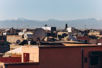 Hermosa vista de la ciudad de Marrakech con casas tradicionales, tejados y montañas en el día soleado, Marruecos, África - foto de stock