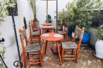 Runde Holztische, gemütliche Stühle und Topfpflanzen im Café im Freien, Marokko, Afrika — Stockfoto