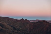 Vista aérea de belas montanhas com céu bege e rosa durante o pôr do sol em Marrocos, África — Fotografia de Stock