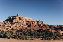 Hermosa vista del antiguo castillo y casas en la colina contra el cielo azul en Marruecos, África - foto de stock