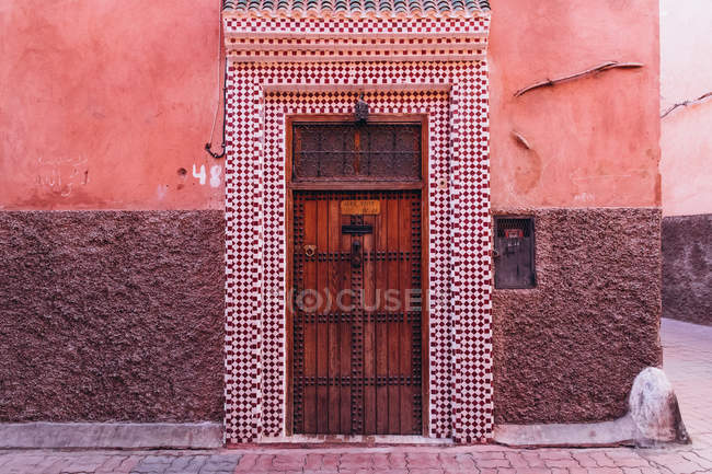 Vieja puerta de madera y puerta de baldosas en la calle de la ciudad en Marruecos, África - foto de stock