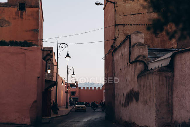 Марракеш, Марокко, Африка - 07 декабря 2018 года: автомобили и мотоциклы на узкой улочке с традиционной архитектурой вечером, Марокко, Африка — стоковое фото