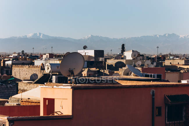 Hermosa vista de la ciudad de Marrakech con casas tradicionales, tejados y montañas en el día soleado, Marruecos, África - foto de stock