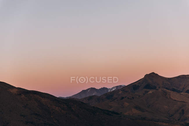 Vista aérea de belas montanhas com céu bege e rosa durante o nascer do sol em Marrocos, África — Fotografia de Stock