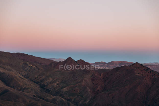 Vista aérea de belas montanhas com céu bege e rosa durante o pôr do sol em Marrocos, África — Fotografia de Stock