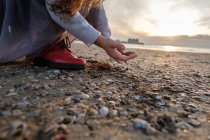 Vista cortada de menina com pedras na praia, foco seletivo — Fotografia de Stock