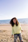 Mulher com cabelo encaracolado ouvir música na praia, foco em primeiro plano — Fotografia de Stock