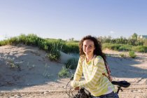 Attraktive Frau mit Fahrrad gegen Strand, Fokus auf Vordergrund — Stockfoto