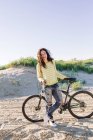 Приваблива жінка з велосипеда проти пляж, зосередитися на передньому плані — стокове фото