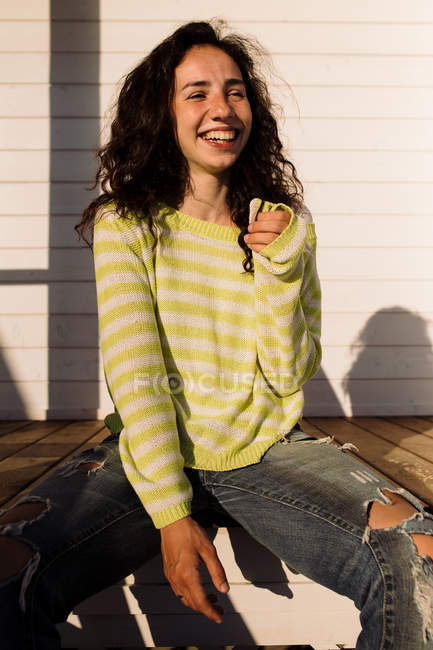 Junge Frau lacht gegen das Bauen, Fokus auf Vordergrund — Stockfoto