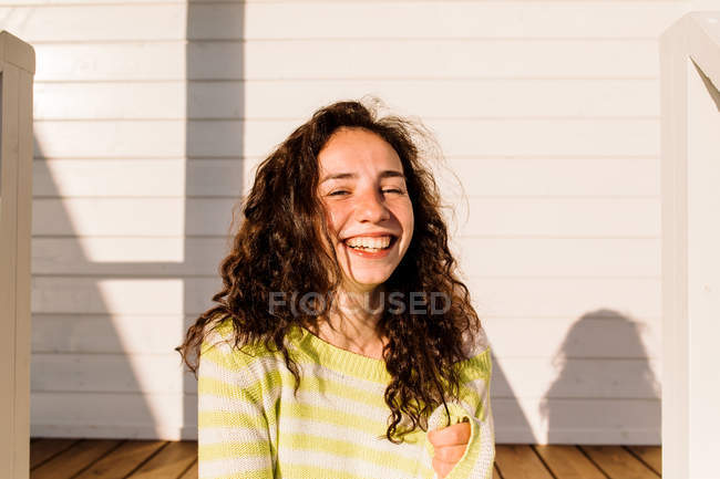 Молода жінка сміється проти будівництва, зосередитися на передньому плані — стокове фото