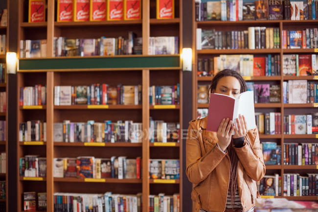 Donna che legge in una libreria — Foto stock