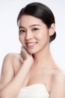 Портрет элегантной молодой азиатской женщины, улыбающейся в камеру, изолированную на сером — стоковое фото