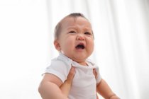 Ritagliato colpo di madre che tiene infante infelice bambino piangendo a casa — Foto stock