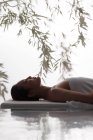 Seitenansicht der attraktiven jungen asiatischen Frau mit geschlossenen Augen, die sich im Wellnessbereich entspannen — Stockfoto