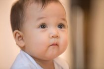Primer plano retrato de adorable asiático bebé niño buscando en casa - foto de stock