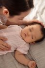 Top view of mother touching adorable baby lying on bed — Stock Photo