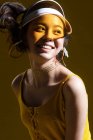 Приваблива щаслива азіатська дівчина в прозорій шапці посміхається і дивиться в студію — стокове фото