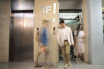 Verschwommene asiatische Geschäftsleute gehen in der Nähe von Aufzug in modernem Büro — Stockfoto