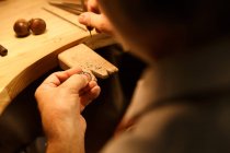 Tiro recortado de diseñador de joyas masculinas trabajando con anillo en el taller, vista sobre el hombro, enfoque selectivo - foto de stock