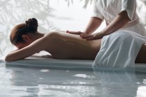 Vista laterale della giovane donna che riceve massaggio corpo in spa, colpo ritagliato — Foto stock