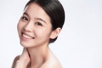 Retrato de elegante feliz joven asiático mujer sonriendo a cámara aislada en gris fondo - foto de stock