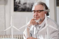 Bearded mature architect in eyeglasses working with wind turbines in office — Stock Photo