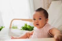 Entzückende asiatische Säugling Baby sitzt auf Schaukelstuhl und schaut in die Kamera — Stockfoto