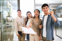 Веселої молоді азіатські бізнес команди працюють разом і посміхатися камери в офісі — стокове фото