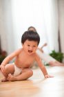 Adorabile eccitato asiatico bambino in pannolino seduta sul pavimento, felice madre seduta dietro — Foto stock
