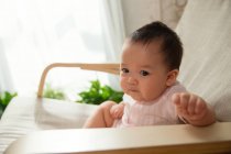 Adorabile asiatico neonato seduta su dondolo sedia a dondolo a casa — Foto stock