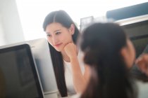 Sourire jeune asiatique femme d'affaires travaillant avec ordinateur dans le bureau — Photo de stock